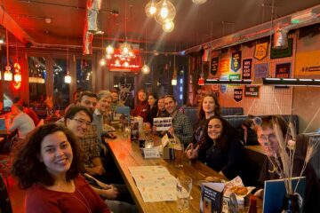 The group sat around a table at Brewdog. In the middle to the right is Alfonso holding up his leaving card.